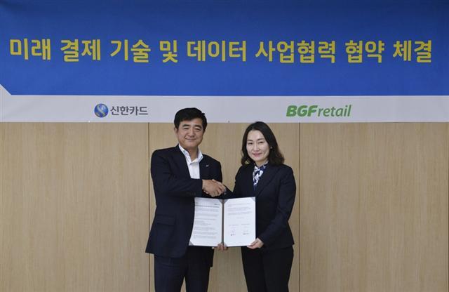 김윤경 BGF리테일 마케팅실장(오른쪽)이 협약 체결 후 이찬홍 신한카드 그룹장이 악수하고 있다.  [제공=BGF리테일]
