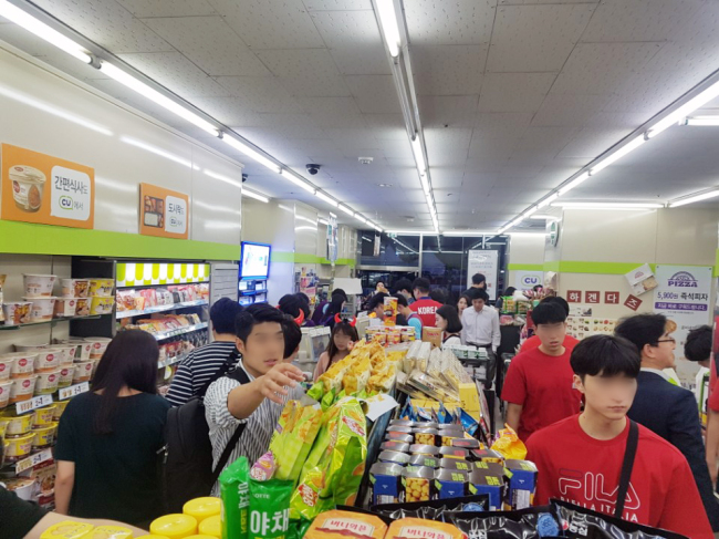 2018 러시아 월드컵 당시 축구 응원 인파가 편의점CU 매장에서 상품을 고르고 있다.[제공=BGF리테일]