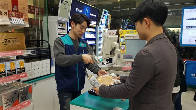 30대 남성 고객이 오피스 상권의 GS25에서 도시락을 구매하고 있다.