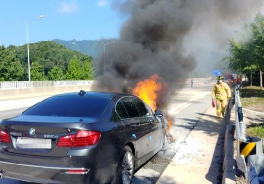 지난해 7월 15일 경북 영주시 장수면 중앙고속도로 춘천 방향 영주휴게소 입구에서 BMW 520d 승용차 엔진룸에서 불이 나 소방대원들이 진화하고 있다.  [연합뉴스]