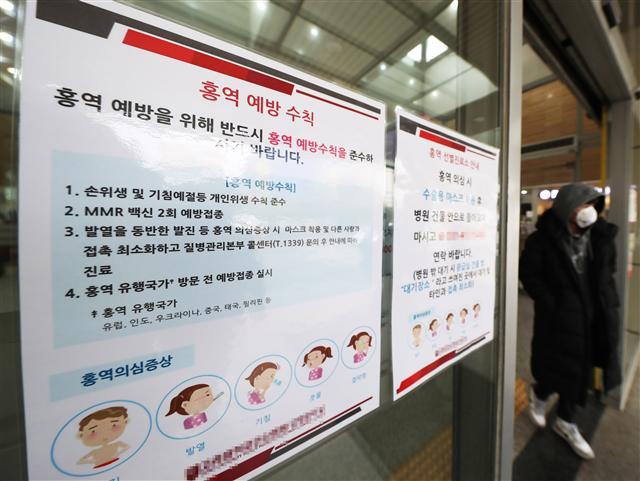 최근 홍역 확진자가 늘면서 대규모 인구 이동이 예상되는 설 연휴를 앞두고 홍역 확산에 대한 불안감이 커지고 있다. 사진은 경기도 안산시의 한 병원 입구에 홍역 예방수칙과 선별진료소 안내문이 붙어 있는 모습.   [연합뉴스]