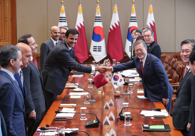 President Moon Jae-in (right) shakes hands with Sheikh Tamim bin Hamad Al Thani, the emir of Qatar, ahead of their summit at Cheong Wa Dae in Seoul on Monday (Yonhap)