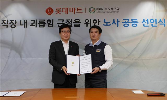 문영표 롯데마트 대표(사진 왼쪽)이 29일 서울 잠실동 소재 본사에서 최석주 노조위원장과 함께 직장 내 괴롭힘 근절을 위한 노사 공동 선언서에 서명을 한 후 기념촬영을 하고 있다.  [제공=롯데쇼핑]