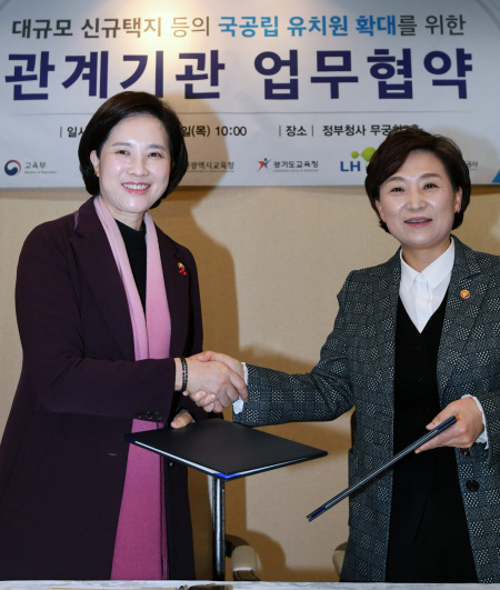 유은혜 사회부총리 겸 교육부 장관(사진 왼쪽)과 김현미 국토교통부 장관이 31일 정부서울청사에서 대규모 신규택지 등의 국공립 유치원 확대를 위한 관계기관 업무협약을 맺고 악수를 나누고 있다. [연합뉴스]