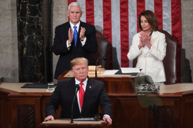 US President Donald Trump, flanked by speaker of the US House of Representatives Nancy Pelosi and US Vice President Mike Pence, takes the podium to deliver the State of the Union address at the US Capitol in Washington, DC, on February 5, 2019. (Photo by SAUL LOEB / AFP)