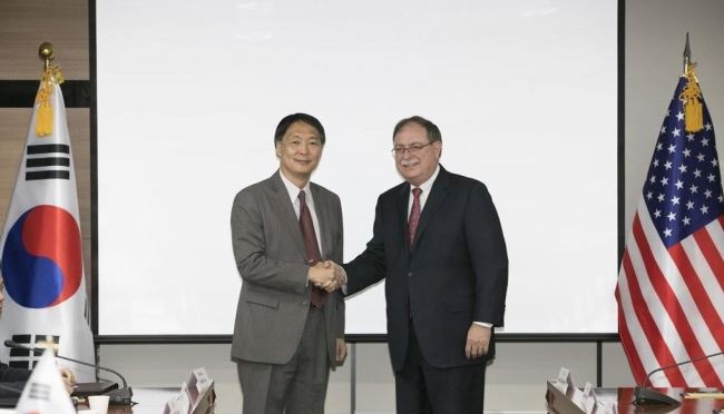 Chang Won-sam (Left), South Korea's negotiator in defense-cost talks with the US, shakes hands with his counterpart, Timothy Betts, during the fourth round of bargaining in Seoul on June 26, 2018. (Yonhap)
