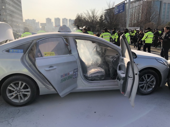 The photo, taken Feb. 11, 2019, shows a taxi after a fire set by the driver was put out by firefighters near the National Assembly in western Seoul. (Yonhap)