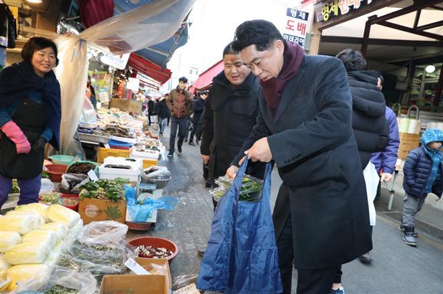 지난달 31일 설맞이 전통시장을 직접 찾아 구매한 물품을 장바구니에 담는 박준희 관악구청장.  [관악구 제공]