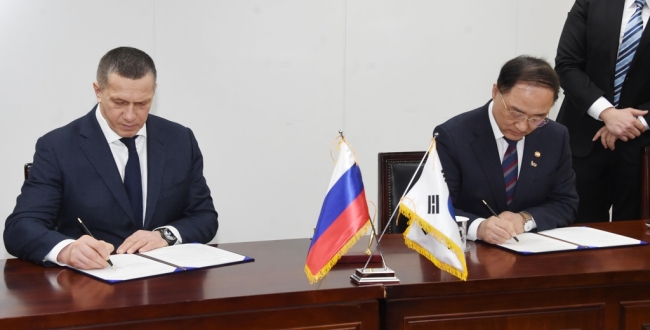 Hong Nam-ki (R), the minister of economy and finance, and Russian Deputy Prime Minister Yuri Trutnev sign an action plan on the "nine bridges" of cooperation at a government building in central Seoul on Feb. 13, 2019. This photo was provided by the ministry. (Yonhap)