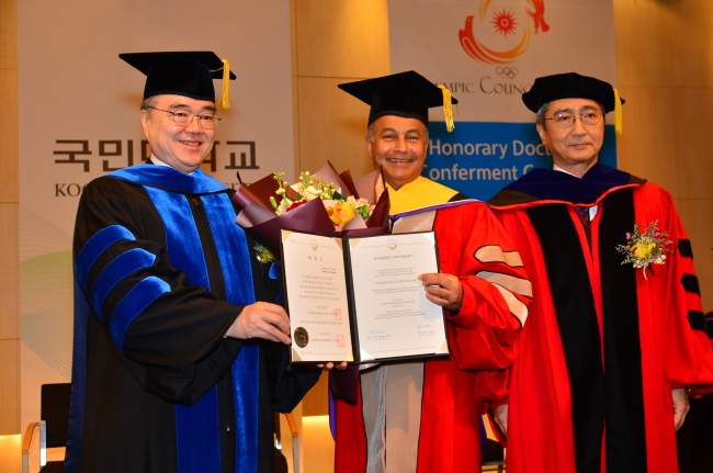 Husain Ali al-Musallam (center), director-general of the Olympic Council of Asia and first vice president of the International Swimming Federation, poses for photographs after receiving an honorary degree from Kookmin University on Monday. Kookmin University President Yu Ji-soo and Dean of Graduate School Park Chan-ryang are seen on the left and right, respectively. / Kookmin University