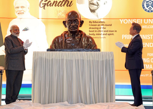 South Korean President Moon Jae-in (R) and Indian Prime Minister Narendra Modi jointly unveil a bust of late Indian leader Mahatma Gandhi in a ceremony at Seoul's Yonsei University on Feb. 21, 2019, as part of India's global project to celebrate the 150th anniversary of Gandhi's birth. (Yonhap)