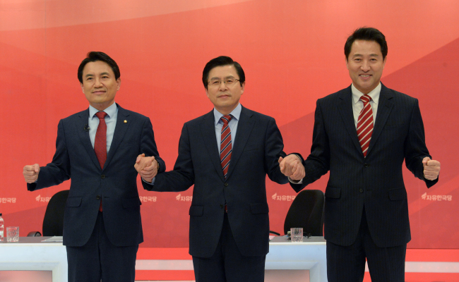 김진태(왼쪽부터), 황교안, 오세훈 당 대표 후보자가 지난 21일 오후 서울 영등포구 여의도 KBS에서 열린 자유한국당 합동TV 토론회에서 손을 맞잡고 있다. [사진=연합뉴스]