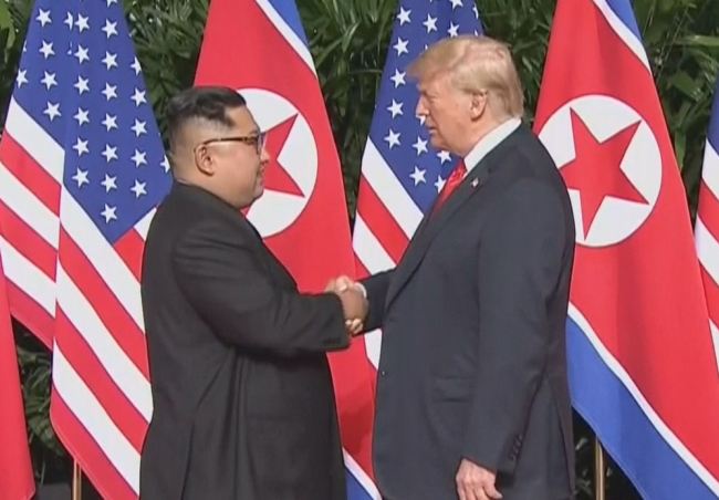 North Korean leader Kim Jong-un (left) shakes hands with US President Donald Trump (right) at the US-North Korea summit held in Singapore in June 2018. (Yonhap)