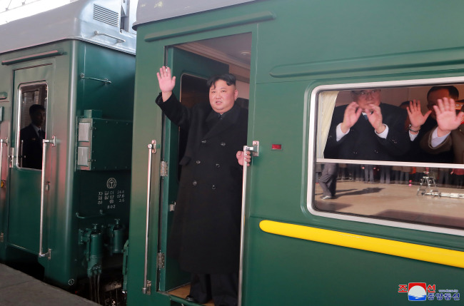 North Korean leader Kim Jong-un waves from the train bound for Hanoi at a train station in Pyongyang on Saturday. Yonhap