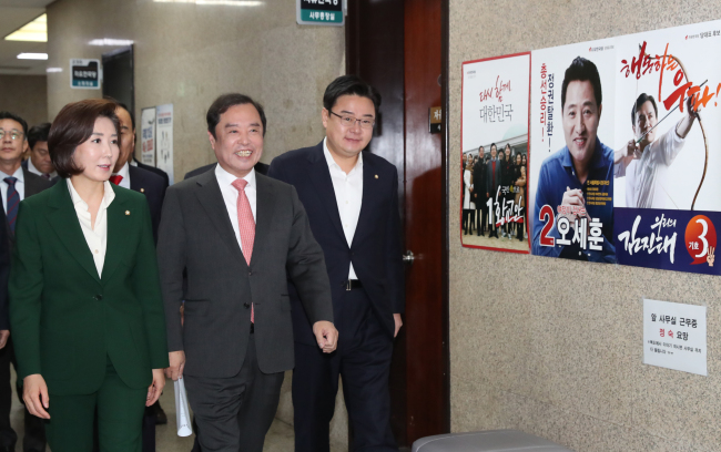 김병준 자유한국당 비대위원장과 나경원 원내대표가 마지막 비대위 회의를 위해 전당대회 당 대표 경선 출마자들의 포스터가 붙어있는 국회 복도를 지나가고 있다(왼쪽). 더불어민주당 이해찬 대표와 최고위원, 당직자들이 25일 국회 당대표회의실에서 열린 3ㆍ1독립선언서 낭독 및 만세 재현 행사에서 만세를 부르고 있다.   [연합]