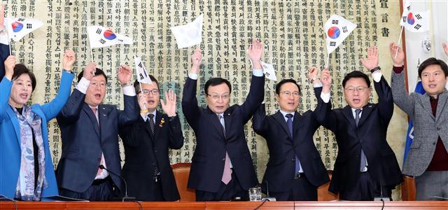 김병준 자유한국당 비대위원장과 나경원 원내대표가 마지막 비대위 회의를 위해 전당대회 당 대표 경선 출마자들의 포스터가 붙어있는 국회 복도를 지나가고 있다(왼쪽). 더불어민주당 이해찬 대표와 최고위원, 당직자들이 25일 국회 당대표회의실에서 열린 3ㆍ1독립선언서 낭독 및 만세 재현 행사에서 만세를 부르고 있다.   [연합]
