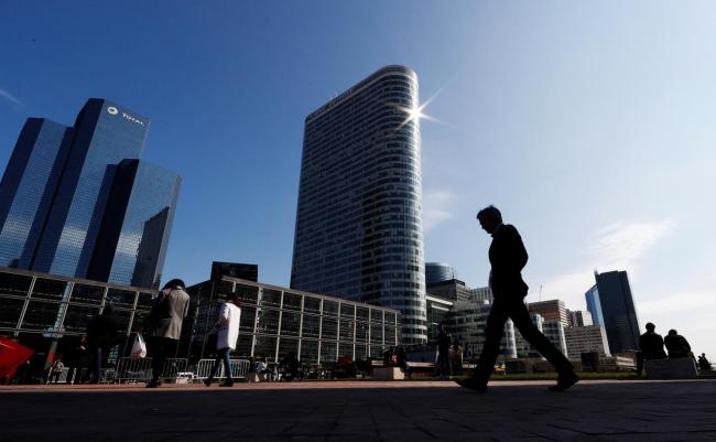 People walk on the esplanade of La Defense in the financial and business district of La Defense, west of Paris, France. (Reuters)