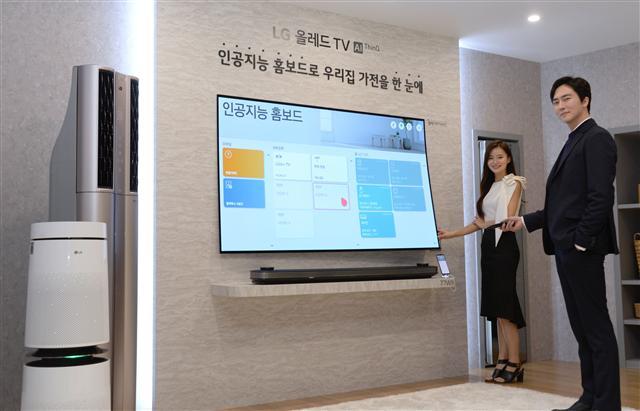 6일 오전 서울 마곡 LG사이언스파크에서 열린 2019년 LG TV 신제품 발표행사에서 모델들이 얇은 월페이퍼 디자인의 77인치 ‘LG 시그니처 OLED TV W’ 제품으로 집안 인공지능 가전을 한눈에 확인하고 간편하게 제어할 수 있는 ‘인공지능 홈보드’ 기능을 소개하고 있다. [LG전자 제공]