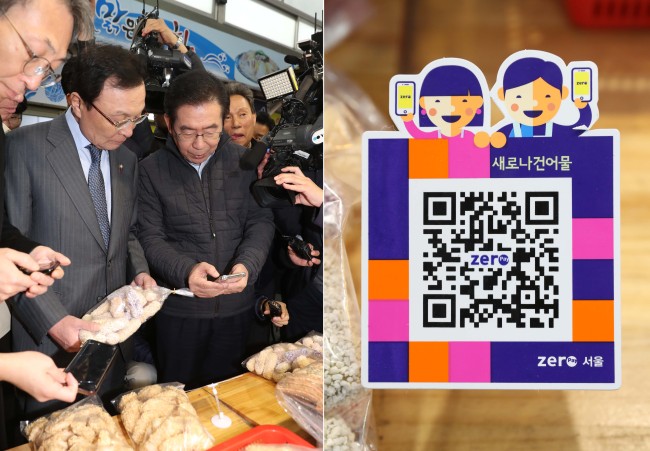 Seoul Mayor Park Won-soon (right) and Rep. Lee Hae-chan, chairman of the ruling Democratic Party of Korea, use Zero Pay to purchase goods at the Sinwon Market in Gwanak-gu, Seoul, Tuesday. (Yonhap)