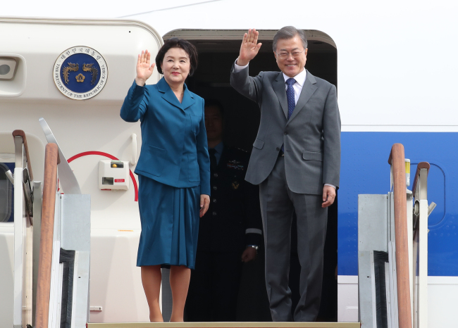 President Moon Jae-in and First Lady Kim Jung-sook wave before departing for a trip of three Southeast Asian nations on Sunday. Yonhap