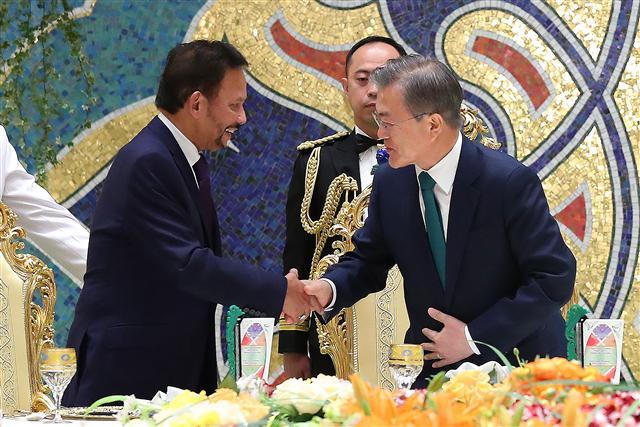 브루나이를 국빈방문 중인 문재인 대통령이 11일 오후 브루나이 왕궁에서 열린 만찬에서 하사날 볼키아 국왕의 만찬사를 들은 뒤 악수하고 있다.    [연합]