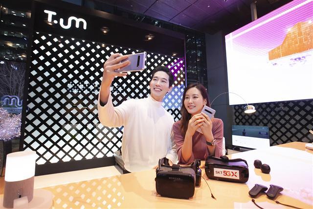 SK텔레콤 모델이 ‘티움’에 전시된 갤럭시S10 5G를 이용해 ‘5G-LTE결합(Aggregation)기술’ 탑재를 알리고 있다.  [SK텔레콤 제공]