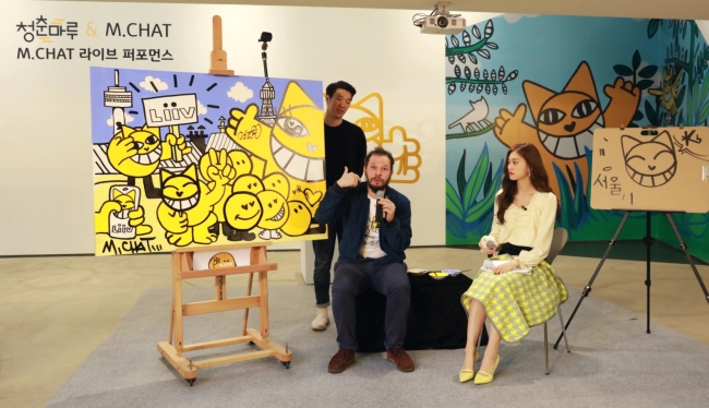Thoma Vuille (left) and K-pop singer Doyeon work on a collaborative M. Chat painting at the KB Rockstar Youth Lounge in Hongdae, northwestern Seoul, Thursday. (KB Kookmin Bank)