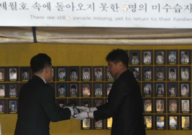 17일 서울 광화문광장 세월호 천막에서 열린 이안식에서 4·16 세월호 참사 유족들이 희생자 영정을 옮기고 있다. 세월호 천막은 2014년 7월 처음 설치된 후 약 4년 8개월 만에 유가족 측의 자진철거 의사에 따라 18일 모두 철거될 예정이다.