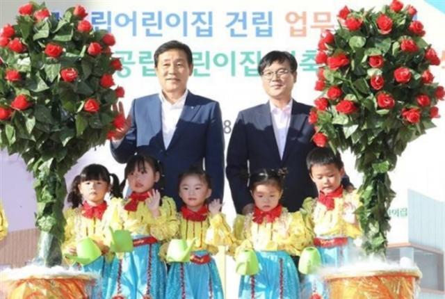 지난해 7월 경남 거제시 아주동 국공립 아주하나어린이집 신축 현장에서 김정태 하나금융그룹 회장(왼쪽)과 변광용 거제시장이 ‘거제시-하나금융그룹 국공립 어린이집 건립 업무협약 및 기공식’을 체결하면서 어린이들과 사진을 찍었다.