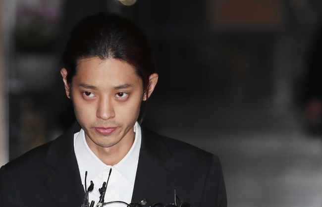 Singer Jung Joon-young leaves Seoul Metropolitan Police Agency after a 21-hour-long interrogation for charges of secretly filming and distributing sex videos concerning at least 10 women via mobile messenger chatroom with eight people, including K-pop star Seungri and FT Island's Choi Jong-hoon, last week. (Yonhap)