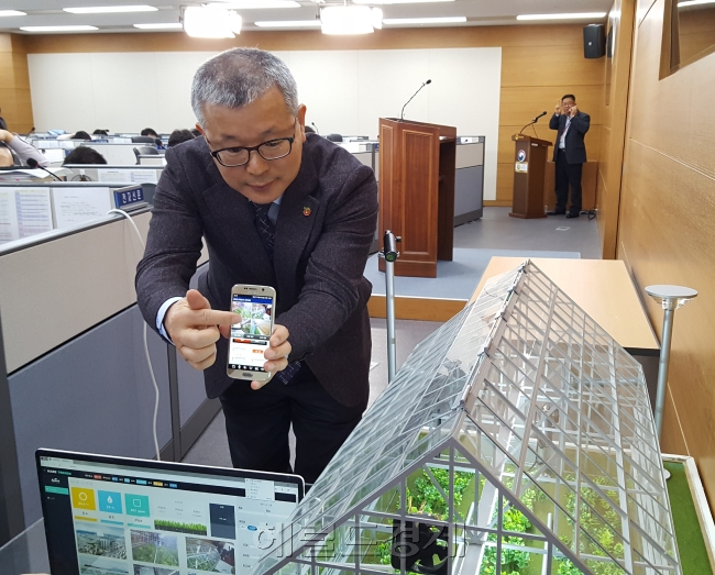 임희택 농업기술실용화재단 총괄본부장이 19일 세종정부청사 농림축산식품부 기자실에서 ‘스마트팜 패키지’ 수출과 관련 모조설비를 놓고 스마트폰으로 다양한 작동을 시연해 보이고 있다. [헤럴드DB]