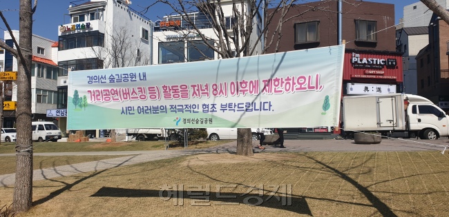 ‘술판 논란’ 경의선 숲길에 금주 권고 표지판이 붙어있다(왼쪽 사진). 인근 주민들은 한때 늦은 시간 계속되는 버스킹 공연으로도 소음 공해를 겪었다.  김유진 기자/kacew@