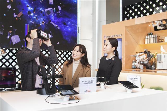 SK텔레콤 직원들이 서울 중구 을지로 본사 1층에서 5G상용망과 연결된 ‘갤럭시S10 5G’를 활용해 다양한 5G서비스를 체험해보고 있다.  [SK텔레콤 제공]