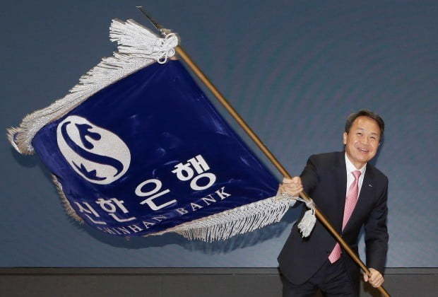 Shinhan Bank's new CEO Jin Ok-dong waves the bank's flag during his inauguration ceremony held at the bank's headquarters in Seoul, Tuesday (Shinhan Bank)