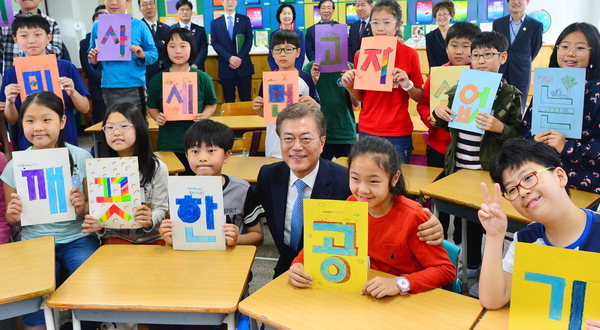 President Moon Jae-in (center) poses for a photo with elementary schoolchildren holding signs that together read "clean air without fine dust." (Yonhap)