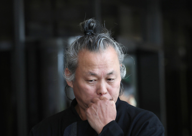 This file photo taken on June 12, 2018, shows South Korean filmmaker Kim Ki-duk listening to reporters' questions at the Seoul Central District Prosecutors' Office in Seoul. (Yonhap)