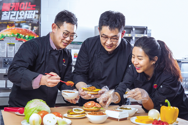 지난 25일 서울 종로구 청진동에 위치한 사무실에서 버거킹코리아 메뉴개발팀 전영욱 총괄 과장(사진 왼쪽)과 이진우 과장(가운데), 김은지 대리가 신메뉴 ‘볼케이노칠리와퍼’를 만들고 있다.  [제공=버거킹코리아]