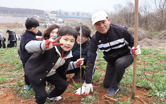 제지연합회 김석만 회장(오른쪽)이 제지회사 가족들과 평택시 안중읍 임야에서 마가목을 심고 있다.  [제지연합회 제공]