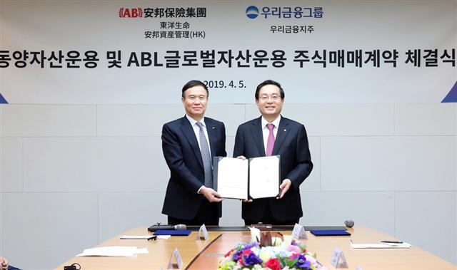 지난 5일 서울 소공동 한진빌딩 본관에서 손태승 우리금융그룹 회장(오른쪽)과 뤄젠룽 동양생명 사장이 주식매매계약을 체결하고 기념사진을 촬영했다.  [우리금융 제공]