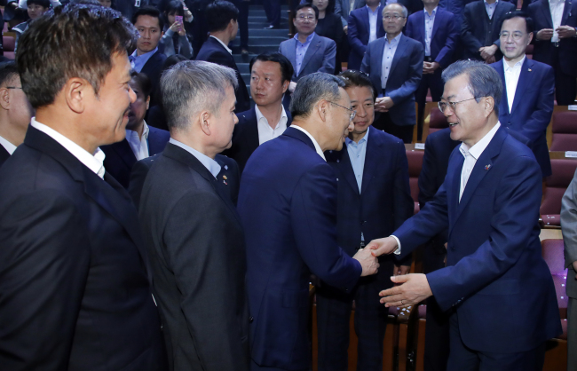 President Moon Jae-in (far right) shakes hands with Korean mobile carriers’ chiefs during an event in Seoul on Monday to celebrate the country’s commercialization of 5G service last week. From left are SKT’s chief Park Jung-ho, LG Uplus’ Ha Hyun-hwoi and KT chief Hwang Chang-gyu. Yonhap