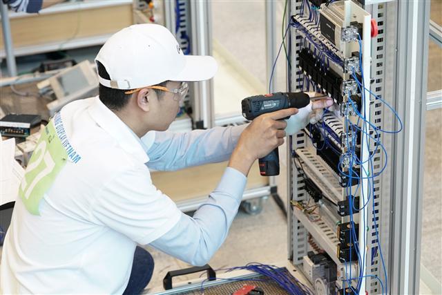 10일 한국기술교육대학교에서 열린 제 12회 ‘삼성국제기능경기대회’에서 4개 전자 계열사 국내외 임직원들이 전기제어시스템제작 직종 경기과제를 수행하고 있다.  [삼성전자 제공]