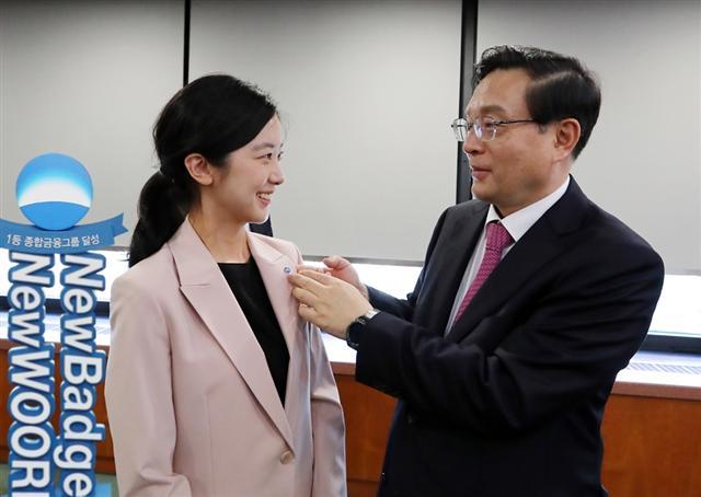 지난 12일 손태승 우리금융 회장이 직원에게 새로운 배지를 달아주고 있다.  [우리금융그룹 제공]