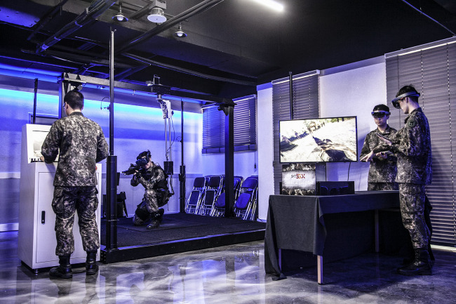 Army soldiers wearing augmented reality goggles monitor combat terrain in a hypothetical military campaign scenario. SKT
　