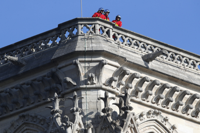 Firefighters inspect Notre Dame Cathedral after a giant fire was put down in Paris 16 April 2019. (Yonhap)