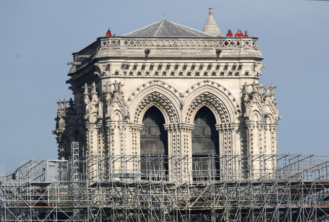 French President Emmanuel Macron vowed to rebuild the 13th century building that welcomes tens of millions of worshippers and tourists per year. (Yonhap)