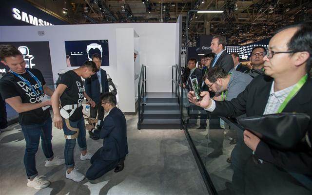 지난 1월 미국 라스베이거스에서 열린 ‘CES 2019’에서 관람객들이 삼성전자 전시관에서 웨어러블 보행 보조로봇의 시연을 보고 있다(사진 왼쪽). LG전자 대표이사 CEO 조성진 부회장(가운데)이 지난해 경영권을 인수한 산업용 로봇 제조업체 ‘로보스타’를 방문해 산업용 로봇을 살펴보고 있다(가운데). 박지원 두산그룹 부회장이 하노버 메세 2019 전시회의 독일 지멘스(Siemens) 전시관에서 관계자의 설명을 듣고 있다.
[삼성전자·LG전자·두산 제공]