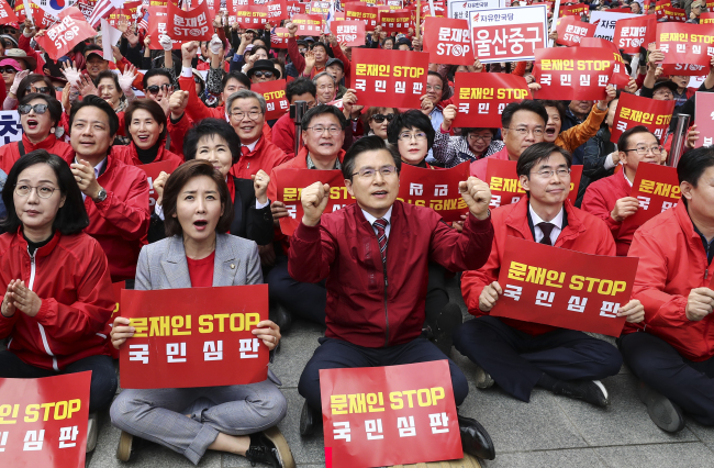 Hwang Kyo-ahn (center), head of the main opposition Liberty Korea Party, and members of the conservative party shout “President Moon Stop” slogans during a rally against the government in central Seoul on Saturday.  Yonhap