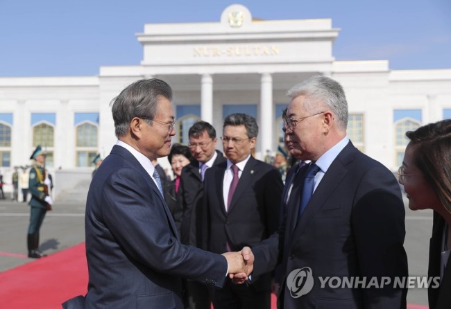 South Korean President Moon Jae-in (L) shakes hands with Kazakh officials at Nur-Sultan International Airport in Nur-Sultan, Kazakhstan, on April 23, 2019, prior to his departure for home, ending a weeklong Central Asia tour that also took him to Turkmenistan and Uzbekistan. (Yonhap)