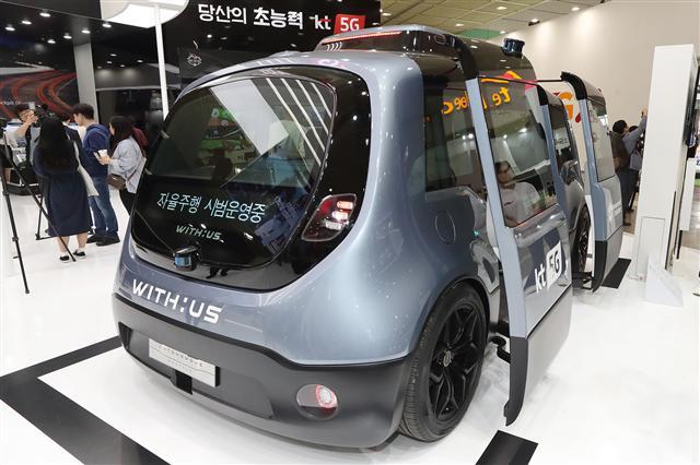관람객들이 KT와 자율주행 전문기업 언맨드솔루션의 자율주행 전용셔틀과 5G 원격관제 시스템을 체험하고 있다.  [KT 제공]