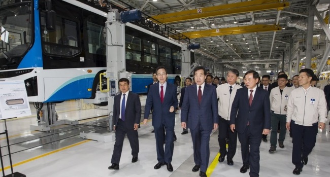 Prime Minister Lee Nak-yon (C) tours a factory of the country's leading carmaker Hyundai Motor Co. in Jeonju, some 243 kilometers south of Seoul, where a hydrogen fuel cell bus is being produced, on April 25, 2019, in this photo, provided by Hyundai Motor. (Yonhap)